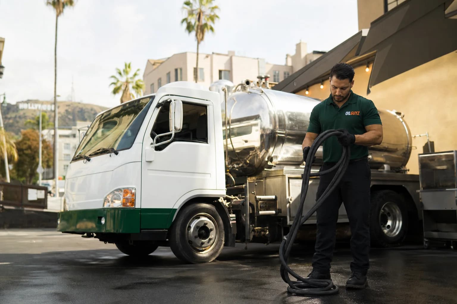 Free used cooking oil pickup at a Lomita restaurant — unbranded white pump truck with hunter-green Oil Guyz technician