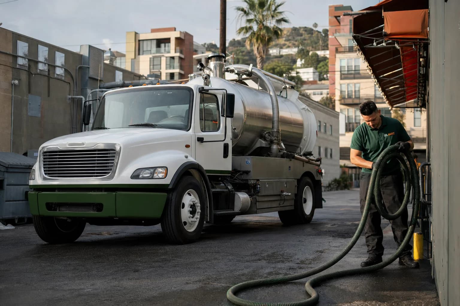 Free used cooking oil pickup at a Montebello restaurant — unbranded white pump truck with hunter-green Oil Guyz technician