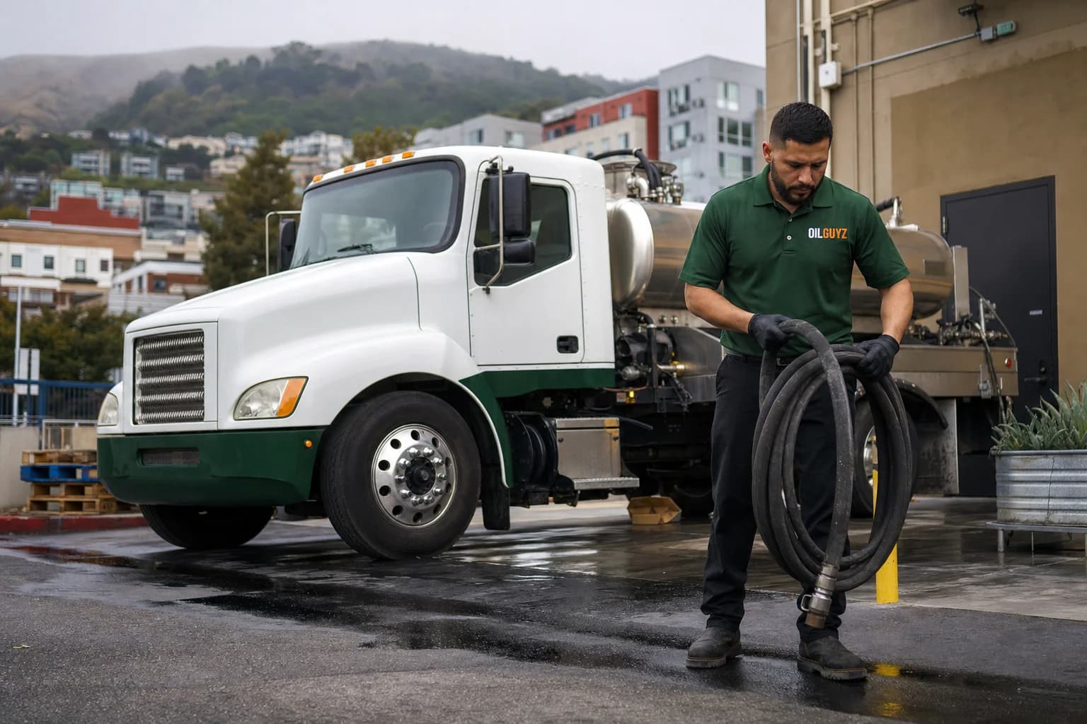 Free used cooking oil pickup at a San Jose restaurant — unbranded white pump truck with hunter-green Oil Guyz technician