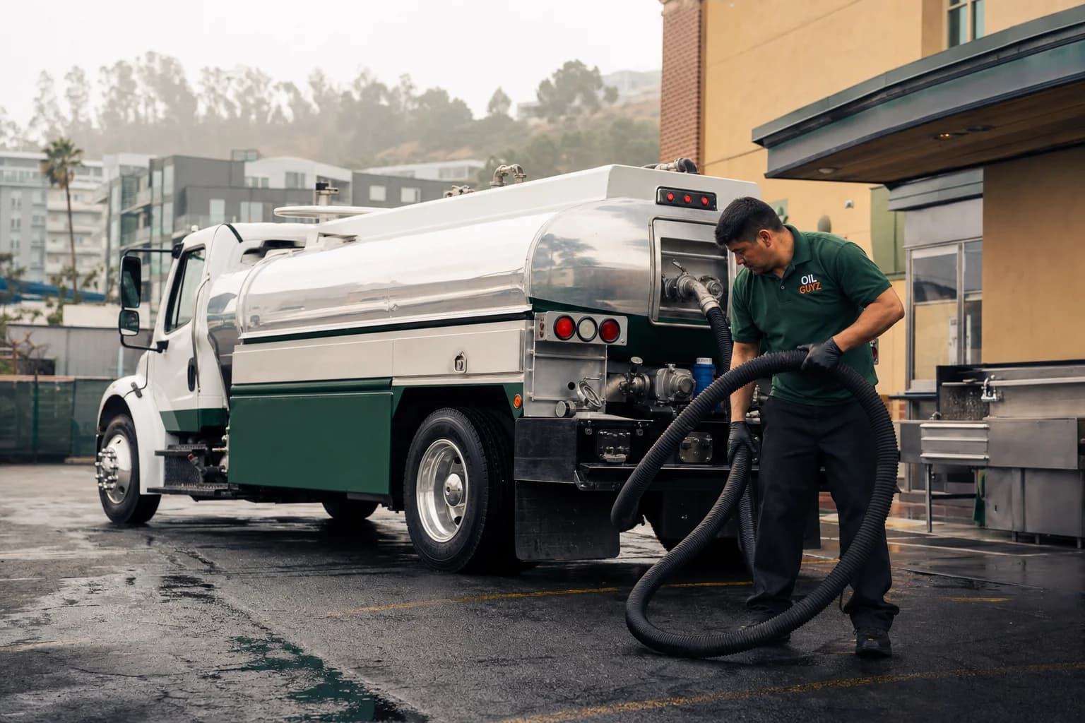 Free used cooking oil pickup at a South San Francisco restaurant, unbranded white pump truck with hunter-green Oil Guyz technician