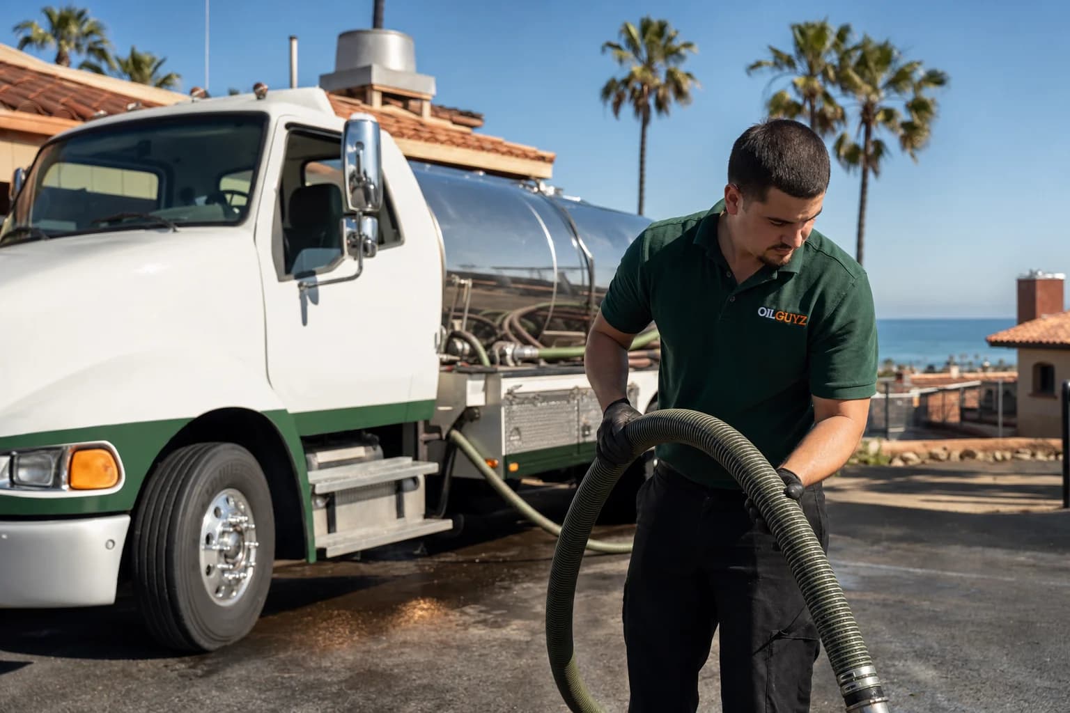 Free used cooking oil pickup at a Vista restaurant — unbranded white pump truck with hunter-green Oil Guyz technician