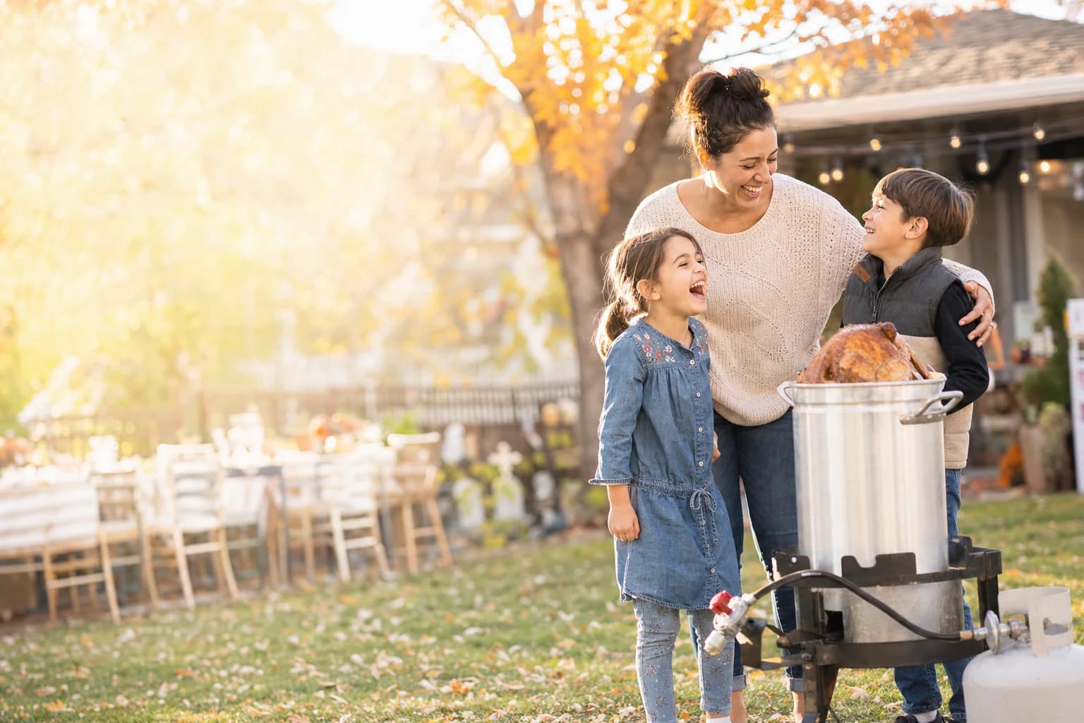 Mom and kids at a backyard Thanksgiving turkey fry