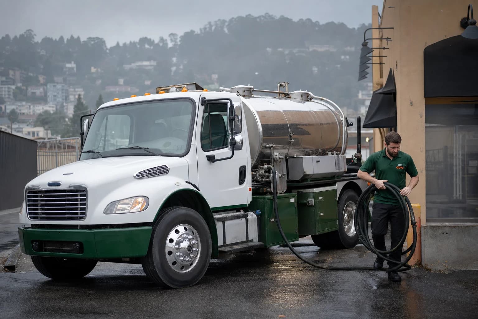 Free used cooking oil pickup at a Berkeley restaurant — unbranded white pump truck with hunter-green Oil Guyz technician