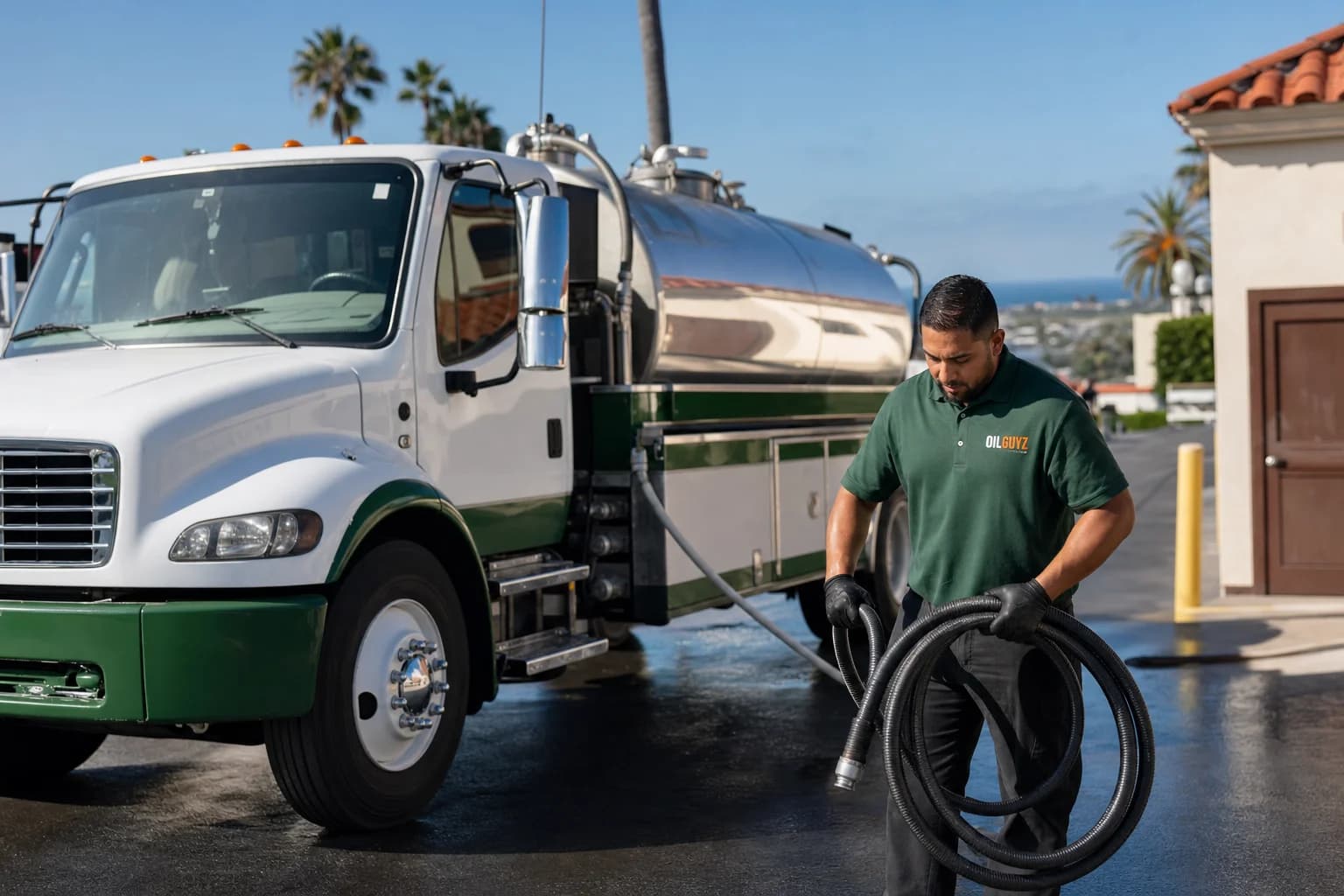 Free used cooking oil pickup at a El Cajon restaurant — unbranded white pump truck with hunter-green Oil Guyz technician