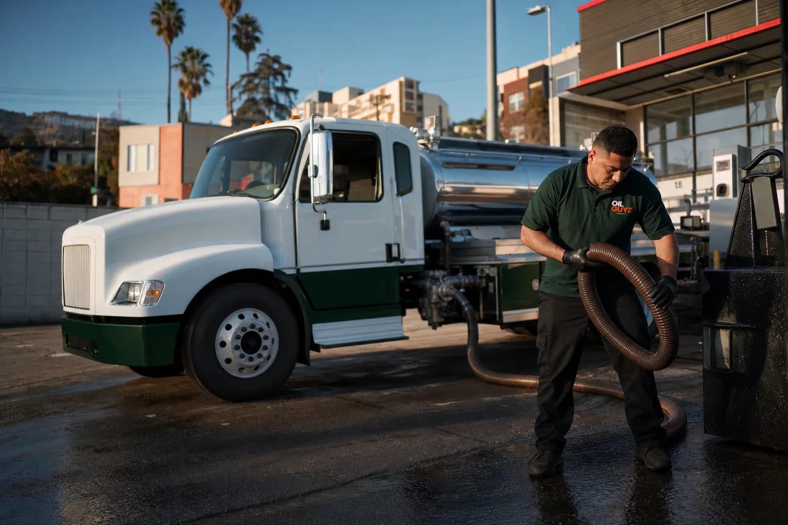 Free used cooking oil pickup at a Gardena restaurant — unbranded white pump truck with hunter-green Oil Guyz technician