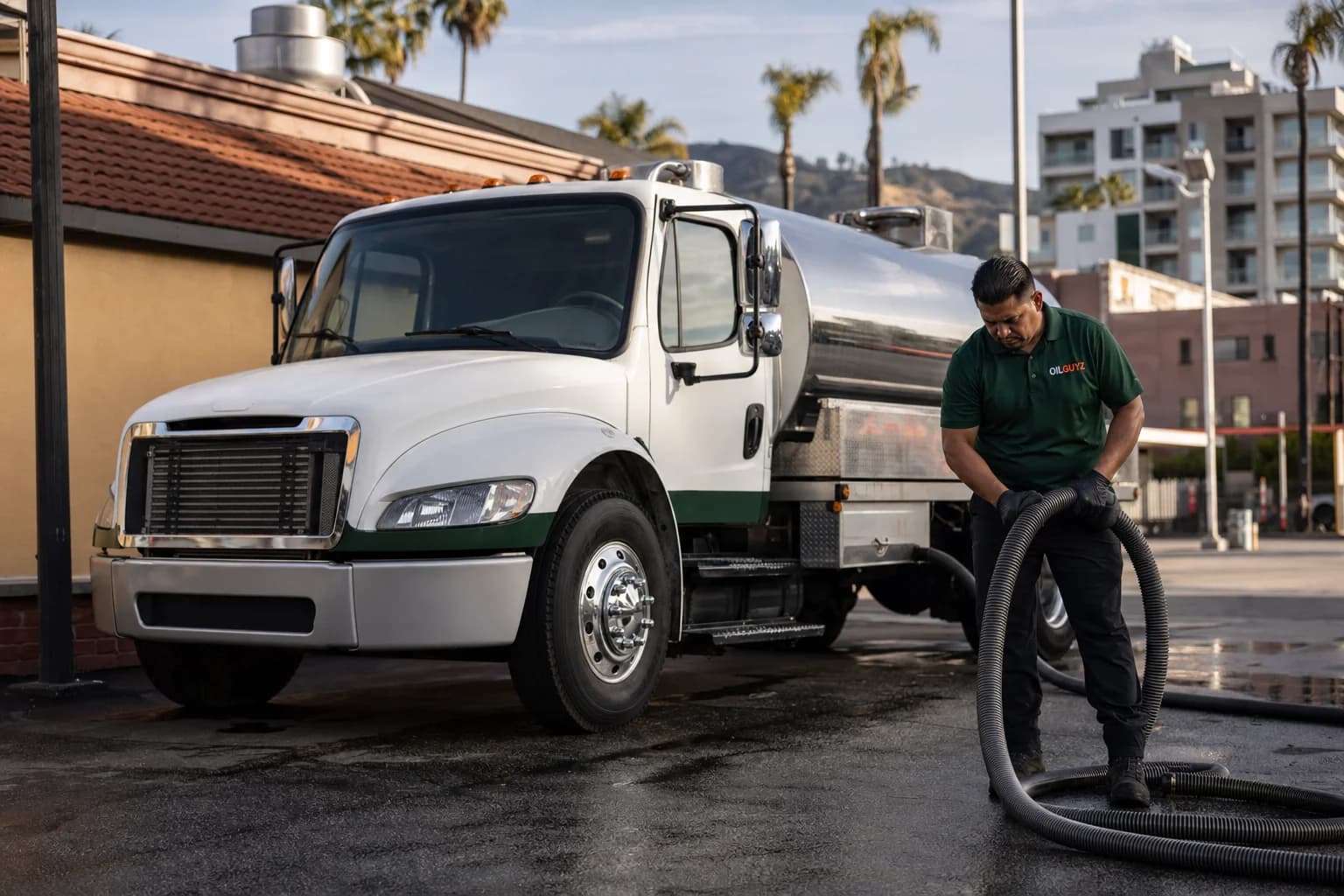 Free used cooking oil pickup at a La Verne restaurant — unbranded white pump truck with hunter-green Oil Guyz technician