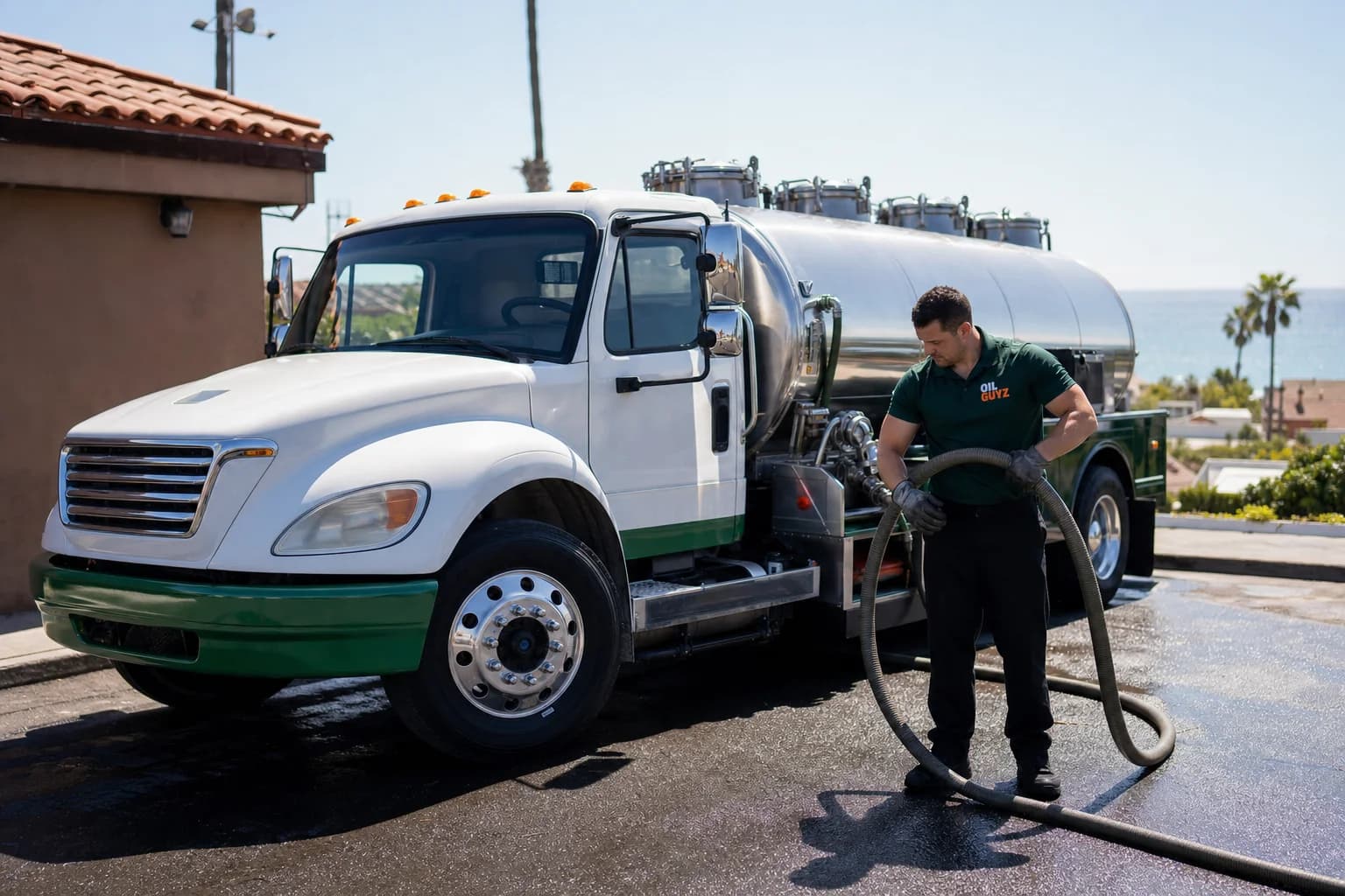Free used cooking oil pickup at a Lemon Grove restaurant — unbranded white pump truck with hunter-green Oil Guyz technician