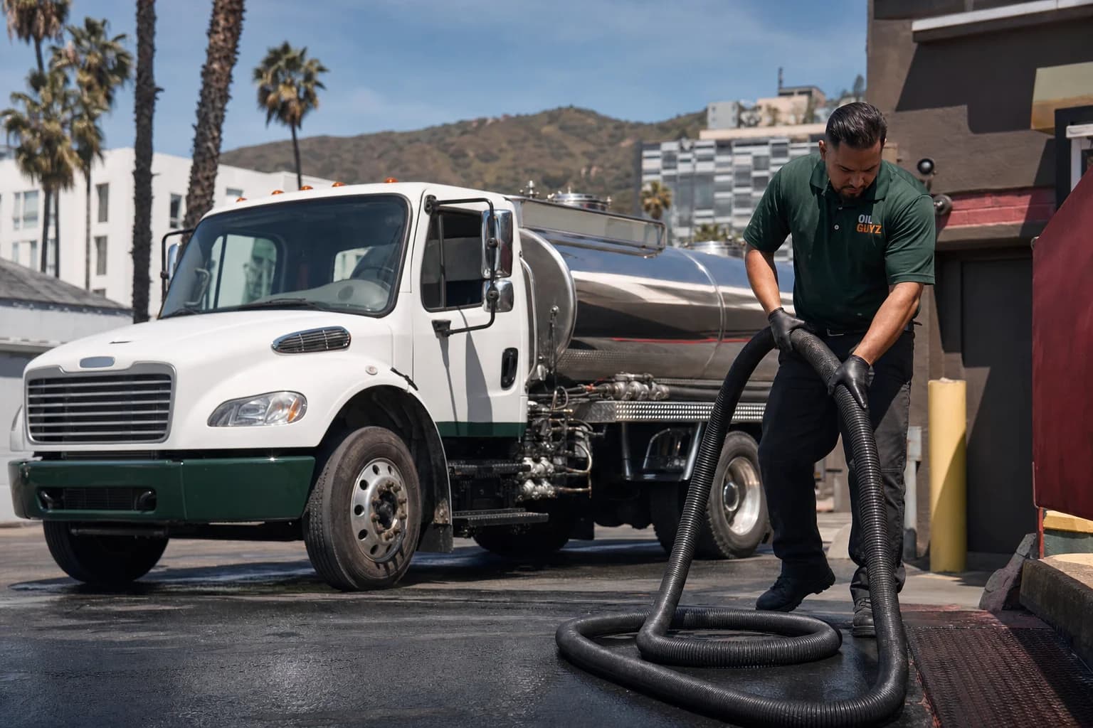 Free used cooking oil pickup at a Maywood restaurant — unbranded white pump truck with hunter-green Oil Guyz technician