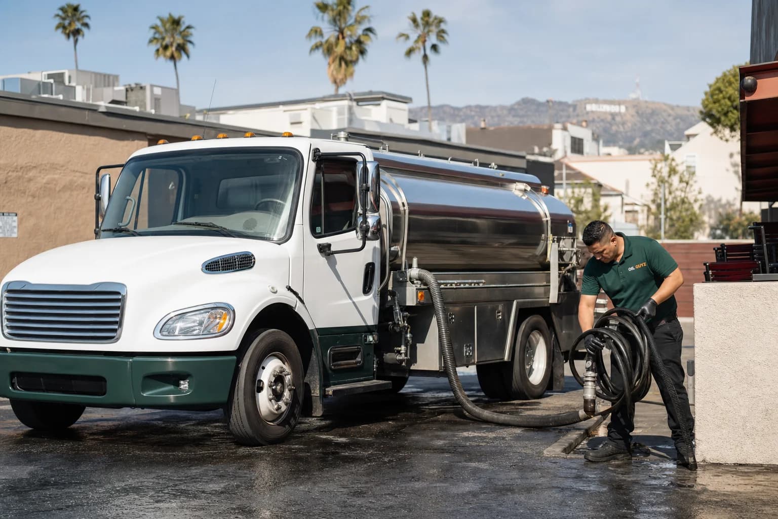 Free used cooking oil pickup at a Rosemead restaurant — unbranded white pump truck with hunter-green Oil Guyz technician