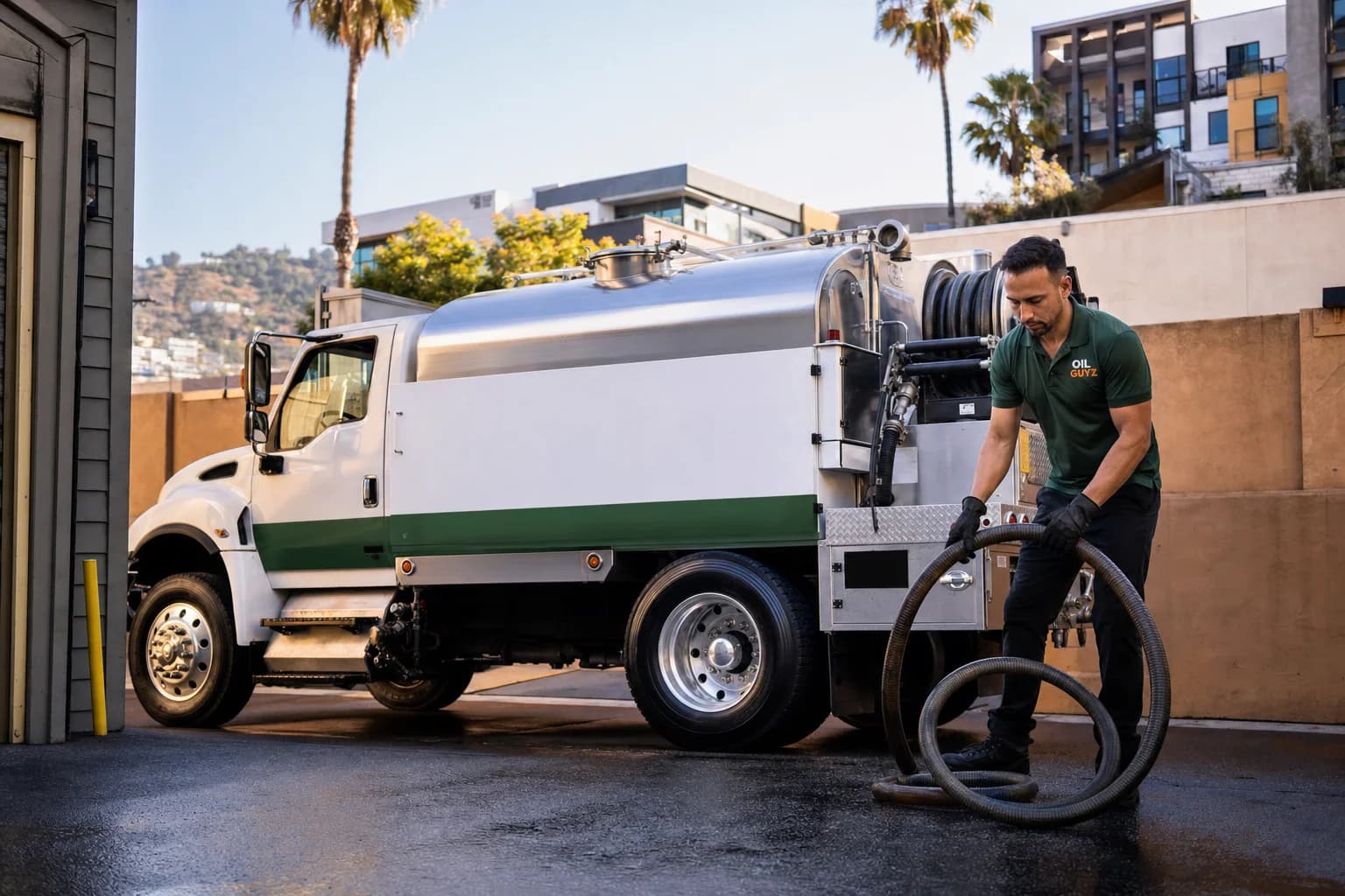 Free used cooking oil pickup at a Santa Fe Springs restaurant — unbranded white pump truck with hunter-green Oil Guyz technician