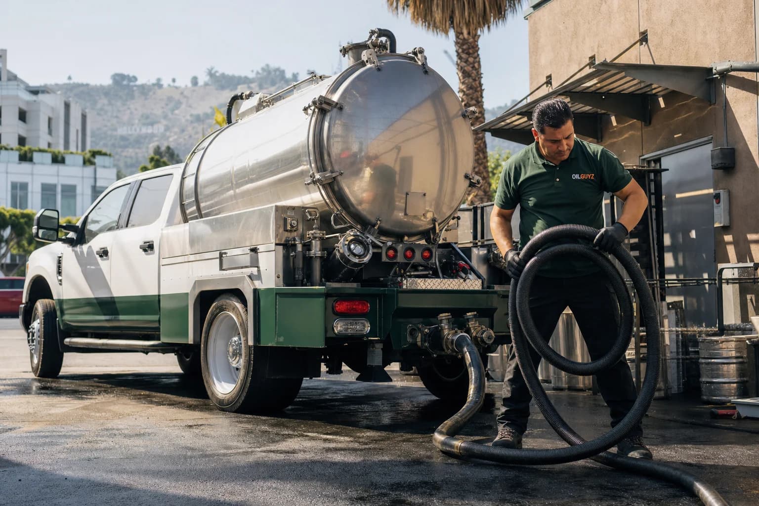 Free used cooking oil pickup at a Sierra Madre restaurant — unbranded white pump truck with hunter-green Oil Guyz technician