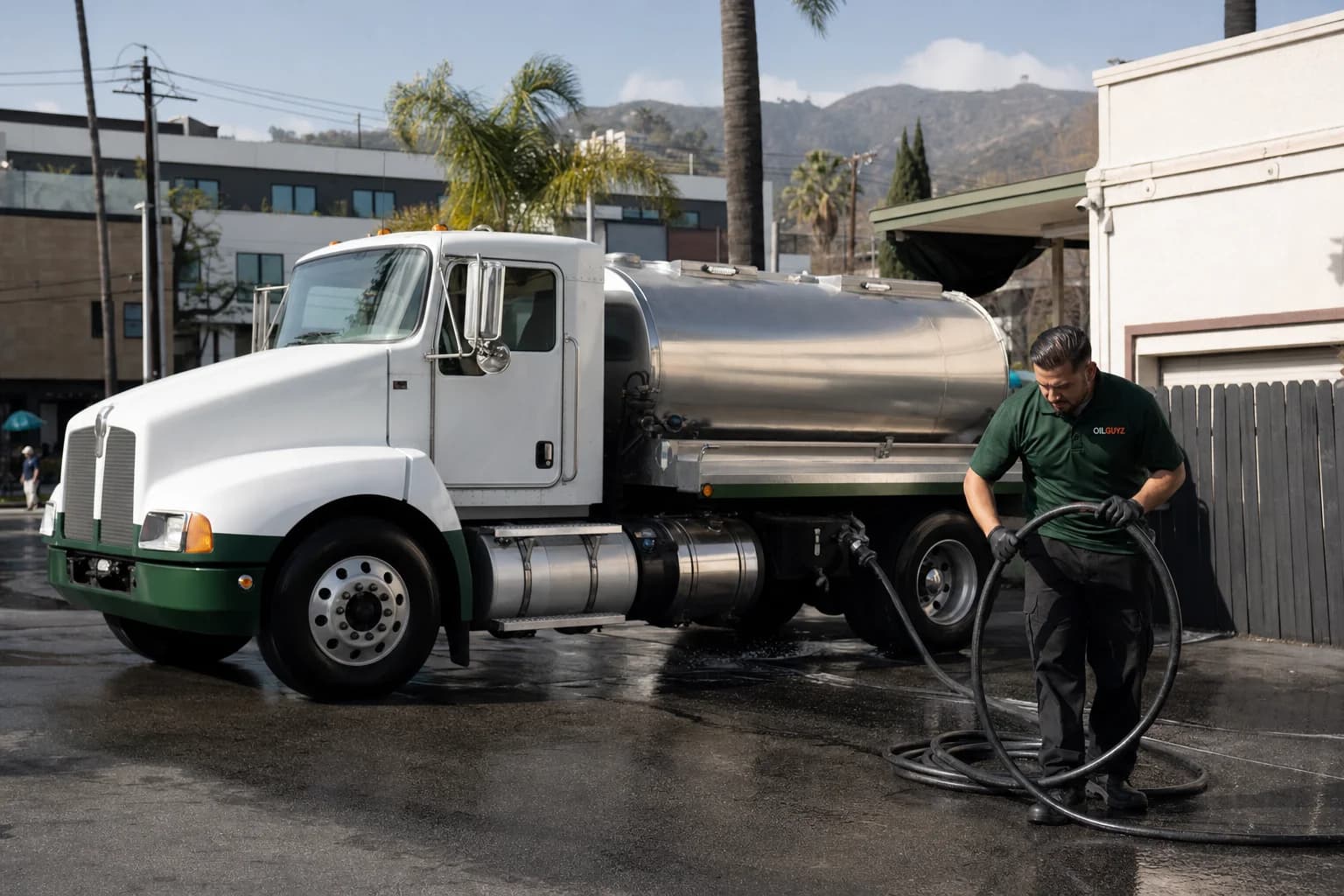 Free used cooking oil pickup at a South Pasadena restaurant — unbranded white pump truck with hunter-green Oil Guyz technician