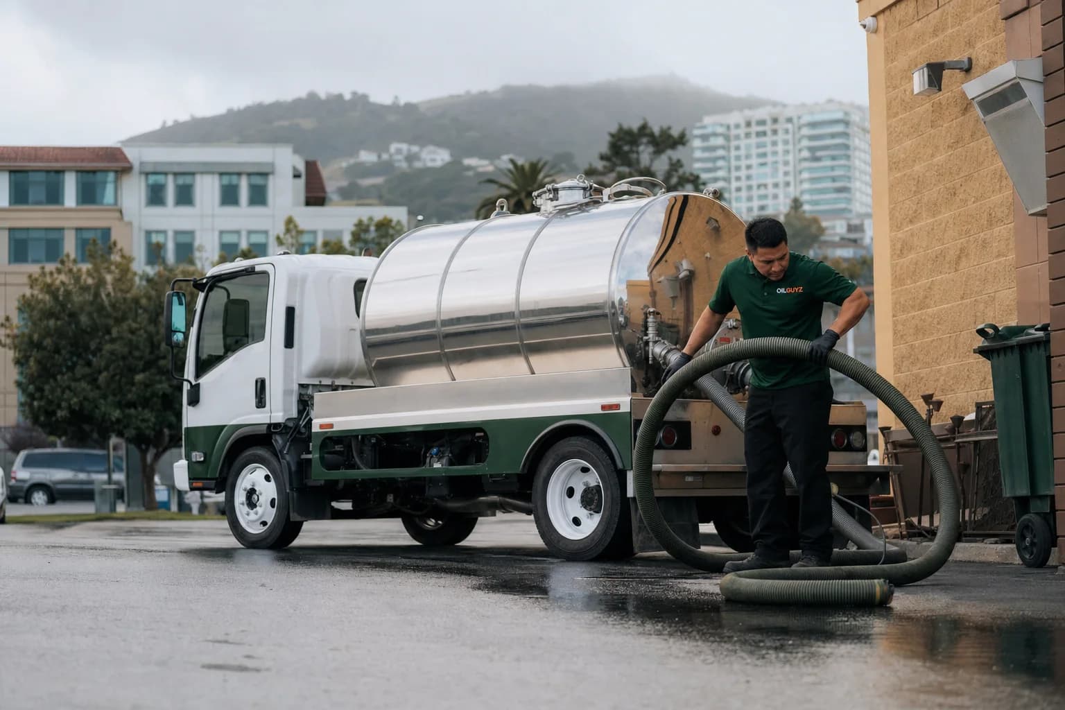 Free used cooking oil pickup at a Sunnyvale restaurant — unbranded white pump truck with hunter-green Oil Guyz technician