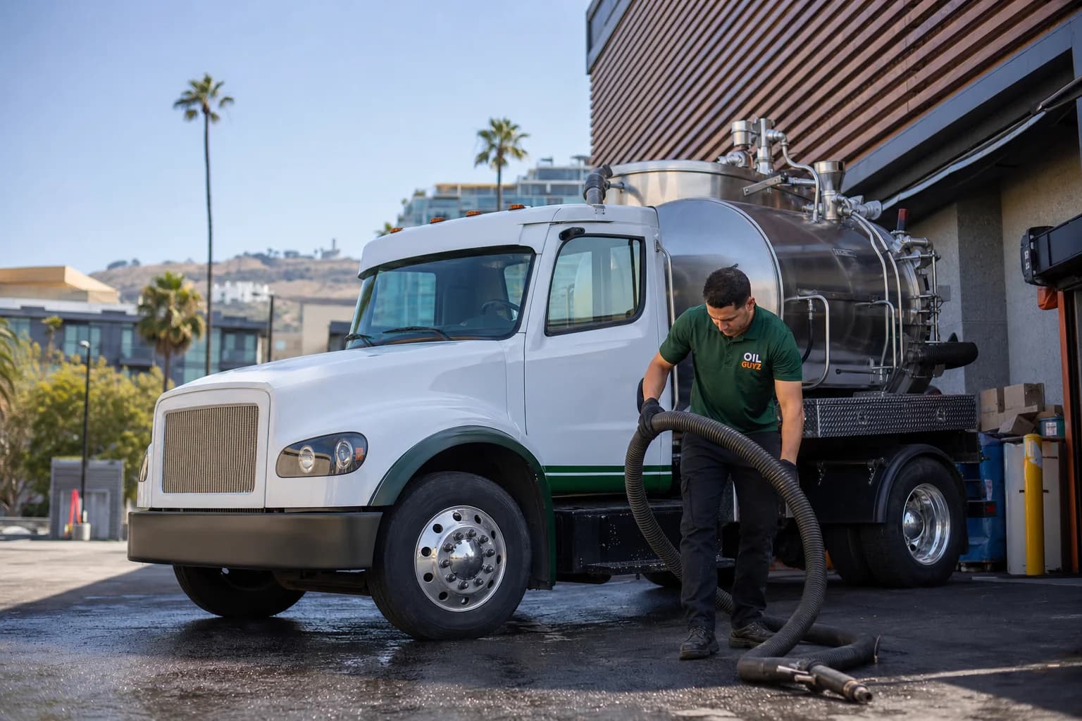 Free used cooking oil pickup at a Torrance restaurant — unbranded white pump truck with hunter-green Oil Guyz technician